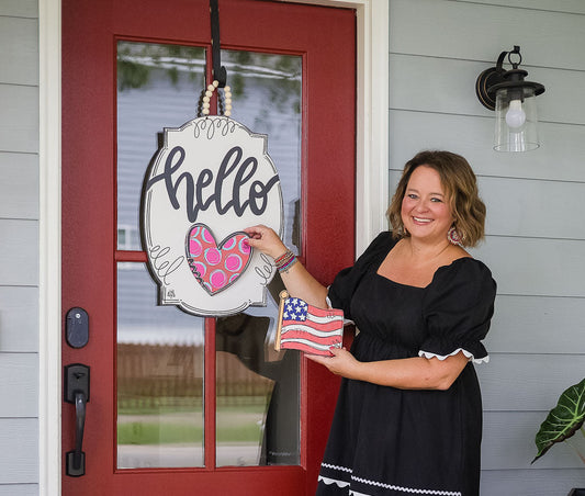 A hello Hanger + Mini on a red front door with a heart Mini, while a flag Mini is swapped in